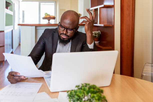 istock Businessman reading rading the bills at home 1217374327