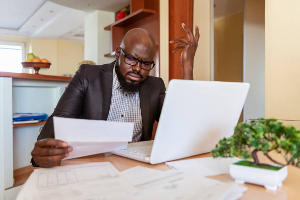 istock Businessman reading rading the bills at home 1217374507