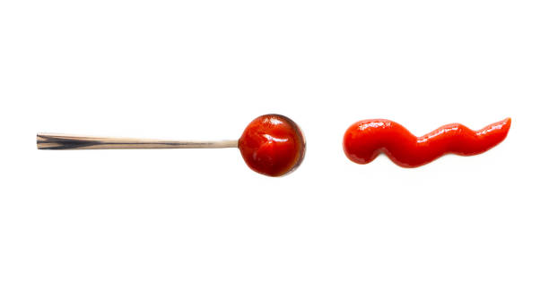 istock Spoon with ketchup and tomato sauce splash isolated on white background, top view 1217376276