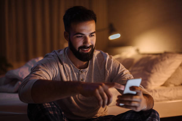istock Handsome bearded man using phone in his bedroom at night 1217377925