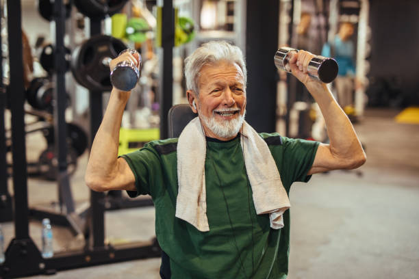 istock Senior man working out with dumbbells at the gym 1217377990