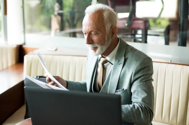 istock Senior businessman working in cafe 1217378375