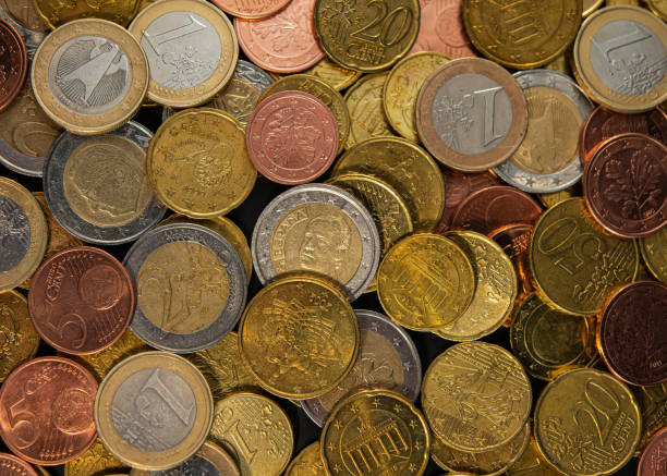 muchos céntimos de euro con monedas de uno y dos euros. - moneda de veinte cinco centavos fotografías e imágenes de stock