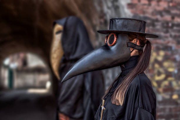 um casal apaixonado pelas fantasias e máscaras de um médico da peste durante a epidemia - namorados negros - fotografias e filmes do acervo