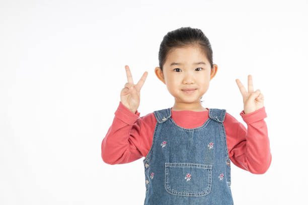 istock Little girl making V shape gesture on White Background 1217380844