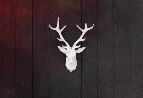 one old gray metal brazier in brown rust with a figure of a deer on the street against the background of green grass