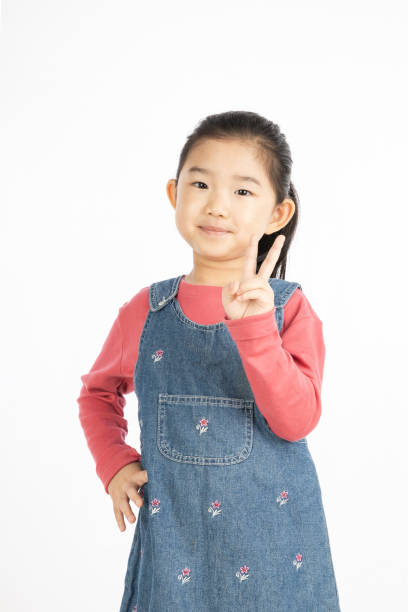 istock Little girl making V shape gesture on White Background 1217381775