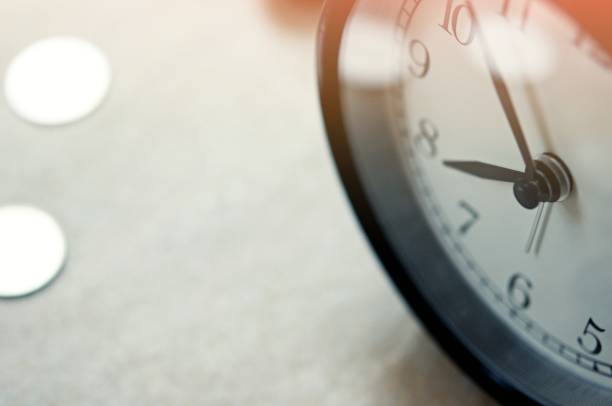 istock vintage alarm clock show before 8 o'clock on the table with green leafs blurred background 1217384322