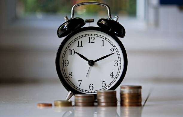 istock vintage alarm clock show before 8 o'clock on the table with green leafs blurred background 1217384401