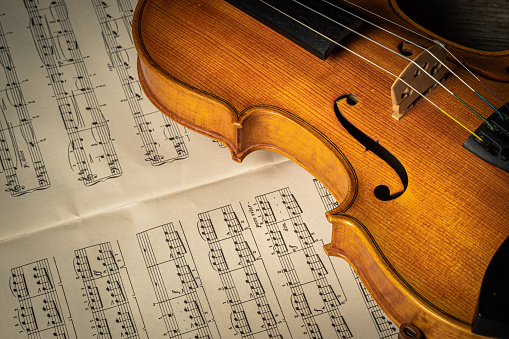 A classical violin lies on sheet music.