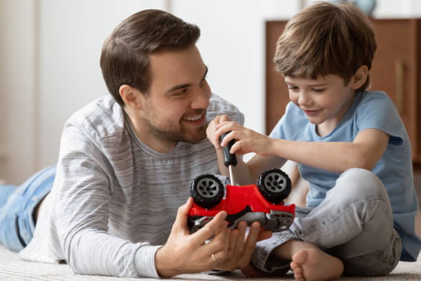istock Caring young dad playing at home with little son 1217386150