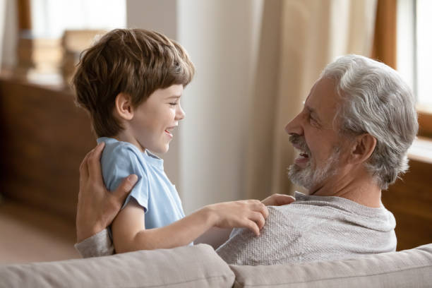 istock Smiling elderly grandfather playing with small grandson 1217386218