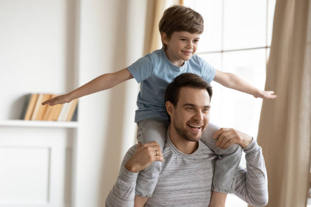 istock Happy young dad and little son playing at home 1217386270