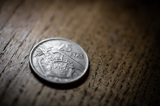 Old coins on antique wood table: 25 Pesetas