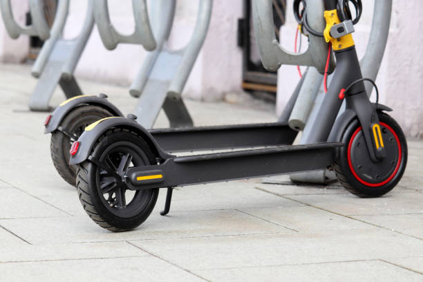 scooters eléctricos seguidos en el estacionamiento - ciclomotor vehículo de motor fotos fotografías e imágenes de stock
