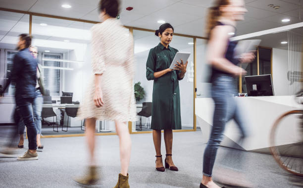 istock Businesswoman standing in the lobby, using digital tablet 1217391036