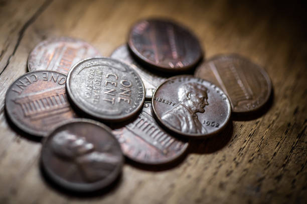istock Old coins on antique wood table: One cent coins penny 1217391083