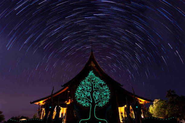 night view of wat sirindhorn wararam phu prao, glow in the dark temple under the long exposure star trail rotation, ubon ratchathani, thailand - luminant imagens e fotografias de stock