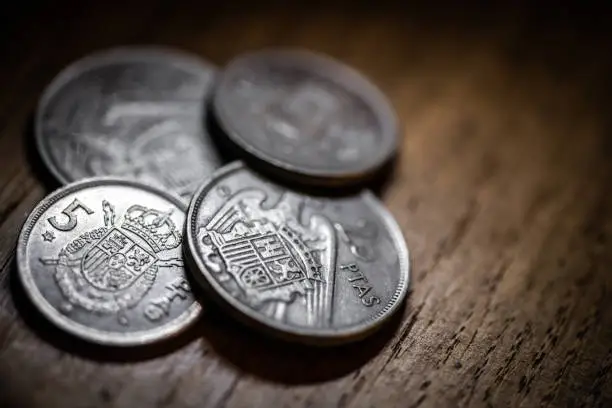 Photo of Old coins on antique wood table: Spanish pesetas