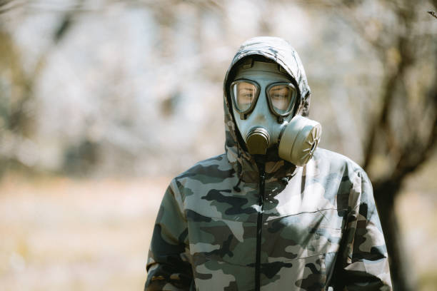 a female soldier wearing a gas mask at the time of covid-19 - judgement day city hydrogen bomb fire imagens e fotografias de stock