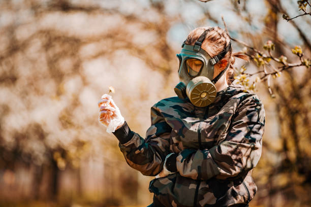 a female soldier wearing a gas mask at the time of covid-19 - judgement day city hydrogen bomb fire imagens e fotografias de stock