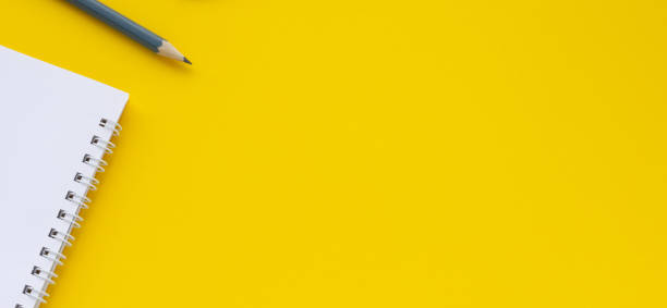 istock Notebook, pencil on a yellow background. Top view space for copy or text. 1217394534