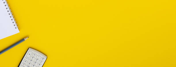 istock Office Style. Calculator, notepad and pencil on a yellow background, space for copy or text 1217394539