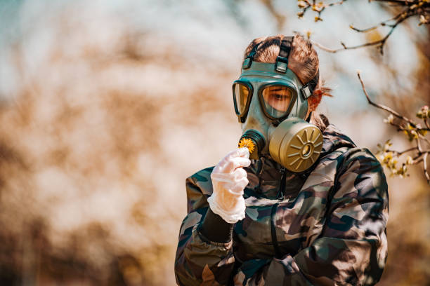 a female soldier wearing a gas mask at the time of covid-19 - judgement day city hydrogen bomb fire imagens e fotografias de stock