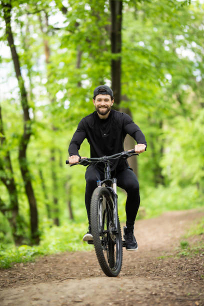 istock Young man riding mountain bike in forest 1217397551
