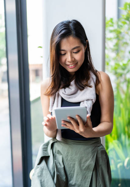 istock Young Asian Millennial working on digital tablet from home 1217398263