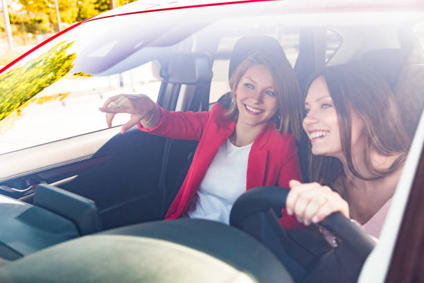 istock Two happy girls in car visible through windshield 1217398388