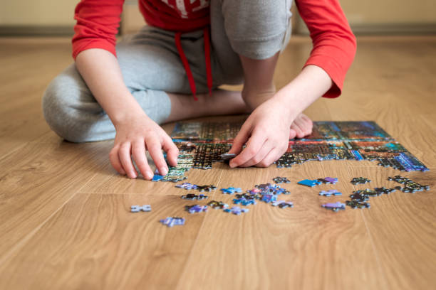 istock Boy collect puzzle sitting on the floor. Solving difficult tasks or stay at home concept. Soft focus. Zero angle 1217398443