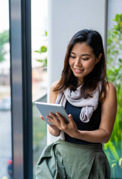 istock Young Asian Millennial working on digital tablet from home 1217398686