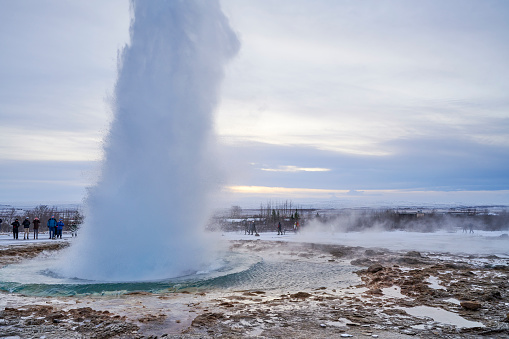 Geysir, Iceland - February 15, 2020: tourists visiting the famous Strokkur Geysir hot spring on a cold day of winter.