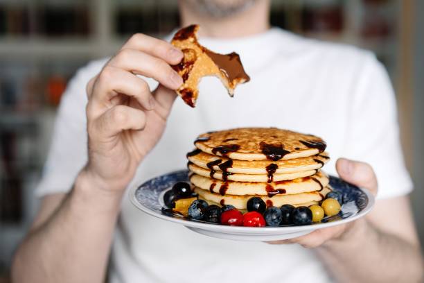 nahaufnahme der hand, die teller mit pfannkuchen hält - eierkuchen speise stock-fotos und bilder