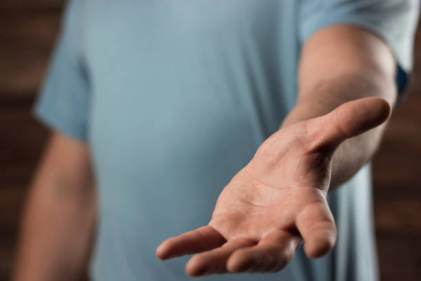 istock young man holds out his hand, a place for posting text or an object 1217402376