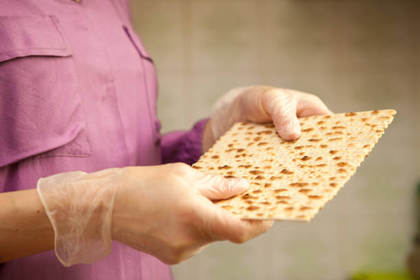 mujer con guantes de protección sostiene matzo - passover matzo bread middle fotografías e imágenes de stock