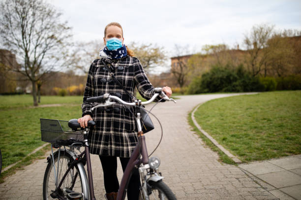 istock Woman with face mask standing with her bicycle during corona virus outbreak 1217404417