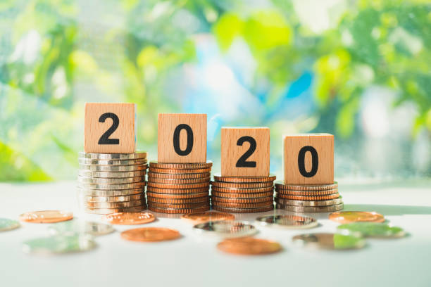 istock Wooden block year 2020 on stack coins 1217404422
