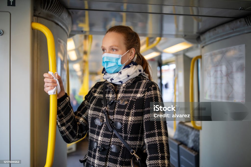 Woman with face mask travelling in metro during Covid-19 outbreak Woman wearing medical face mask commuting in a subway train during corona virus outbreak. Female travelling in metro during Covid-19 pandemic. Protective Face Mask Stock Photo