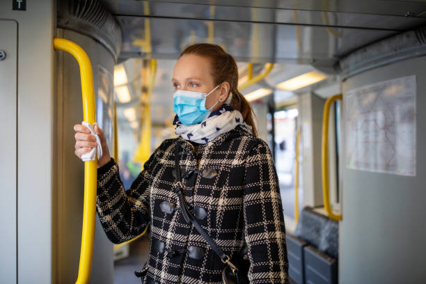 Woman with face mask travelling in metro during Covid-19 outbreak Woman wearing medical face mask commuting in a subway train during corona virus outbreak. Female travelling in metro during Covid-19 pandemic. commercial land vehicle photos stock pictures, royalty-free photos & images