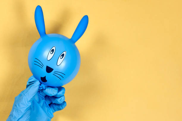 Female hands in medical-surgical gloves holding cute Easter bunny. Celebrating Easter 2020 in quarantine during the covid-19 pandemic. Celebrate Easter holidays at home, stay at home concepts