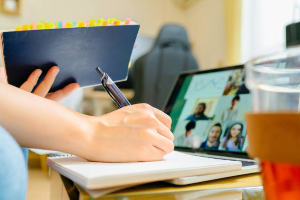 istock Close-up photo of human hand while studying together with other university students via conference call from home 1217406408