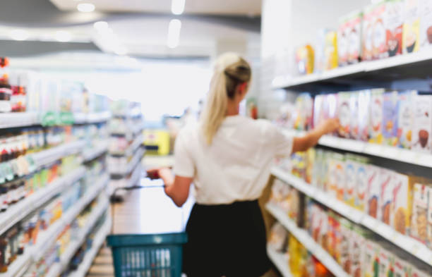 junge frau wählt lebensmittel im supermarkt - shelf pharmacy people indoors stock-fotos und bilder
