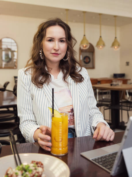 istock Woman sitting alone and working on a laptop in a cafe 1217407804