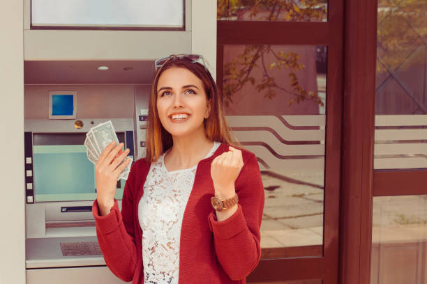 Withdraw.  ATM. Portrait happy smiling woman exults pumping fists ecstatic celebrates success holding cash dollar money bills banknotes isolated outside Atm background with copy space. Casual clothing Withdraw.  ATM. Portrait happy smiling woman exults pumping fists ecstatic celebrates success holding cash dollar money bills banknotes isolated outside Atm background with copy space. Casual clothing free bingo stock pictures, royalty-free photos & images