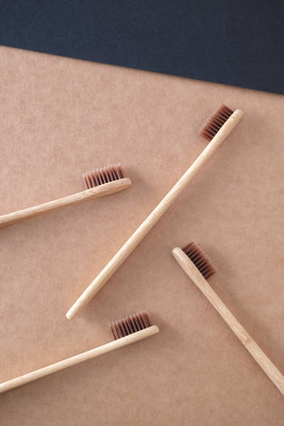 cepillos de dientes de bambú sobre fondo de papel kraft. - dental hygiene elegance black toothbrush fotografías e imágenes de stock