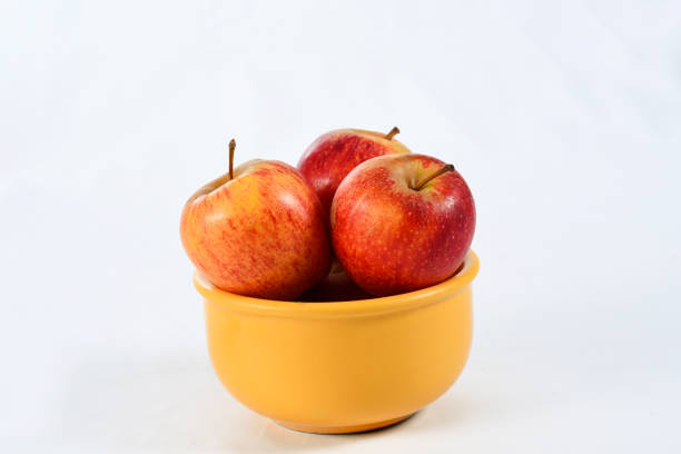 istock natural and healthy apples tropical fruit inside a yellow pot isolated on bench background 1217408972