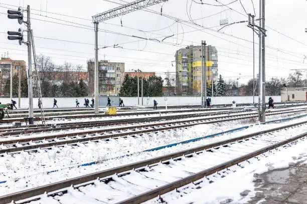 Rivne, Ukraine train station building tracks and platform in Ukrainian city with people walking outside in winter snow cold weather