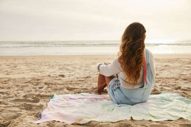 istock Mature woman looking at the ocean view from a sandy beach 1217411213